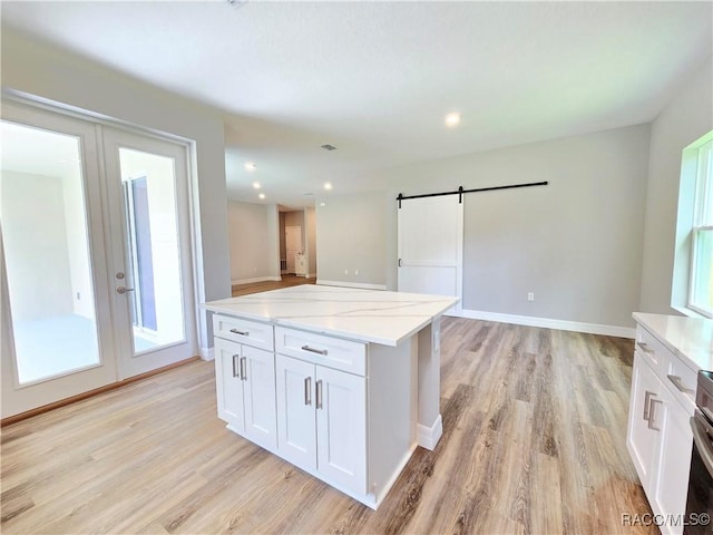 8 Calendula Ct, Homosassa, FL 34446 - kitchen with a barn door, light wood-style floors, french doors, and recessed lighting