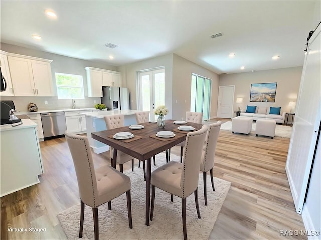 8 Calendula Ct, Homosassa, FL 34446 - dining space featuring light wood-style floors, recessed lighting, and a barn door