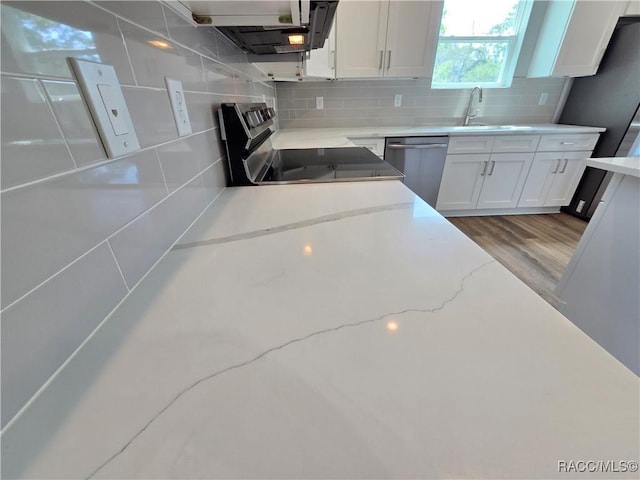 8 Calendula Ct, Homosassa, FL 34446 - kitchen featuring stainless steel dishwasher, a sink, stove, and white cabinetry