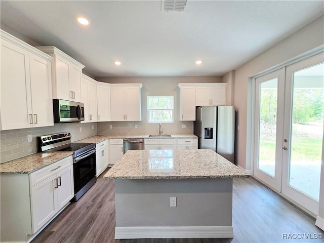 kitchen featuring stainless steel appliances, tasteful backsplash, visible vents, and a sink