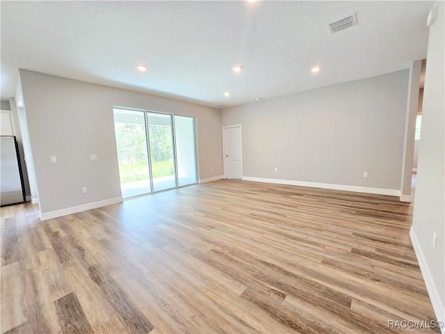 8 Calendula Ct, Homosassa, FL 34446 - unfurnished room featuring light wood-type flooring, recessed lighting, baseboards, and a textured ceiling
