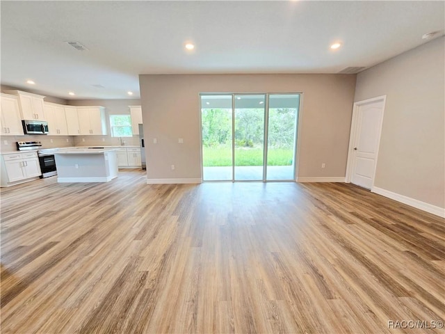 8 Calendula Ct, Homosassa, FL 34446 - unfurnished living room featuring baseboards, light wood-type flooring, and recessed lighting