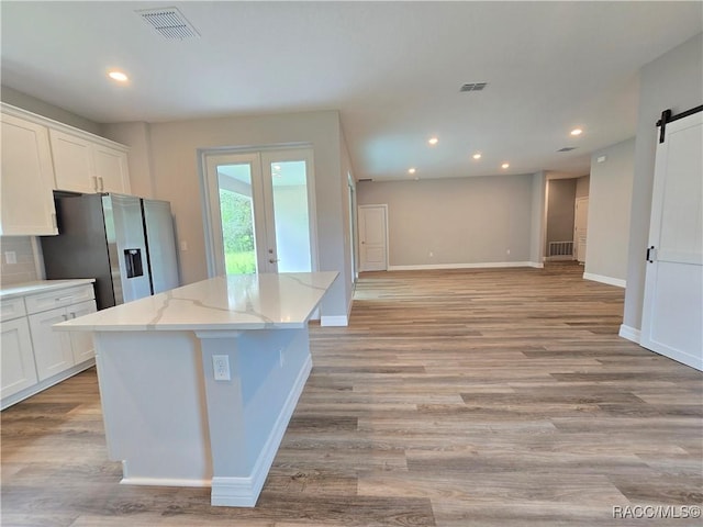 8 Calendula Ct, Homosassa, FL 34446 - kitchen featuring a barn door, a center island, white cabinetry, light wood-style flooring, and recessed lighting