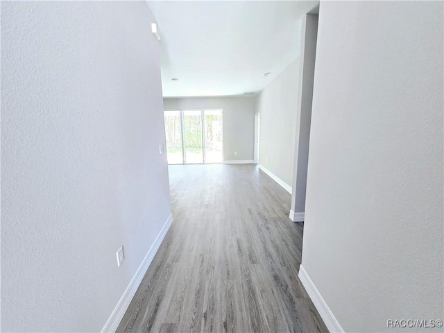 hallway with wood finished floors and baseboards