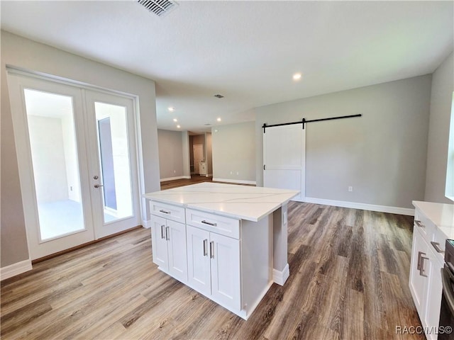 8 Calendula Ct, Homosassa, FL 34446 - kitchen featuring french doors, a barn door, light wood-type flooring, white cabinetry, and recessed lighting