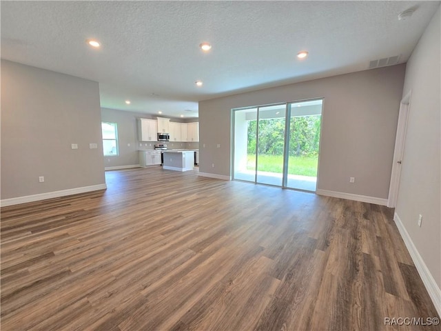 8 Calendula Ct, Homosassa, FL 34446 - unfurnished living room featuring recessed lighting, baseboards, wood finished floors, and a textured ceiling