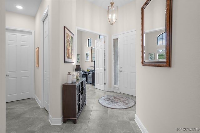 foyer featuring light tile patterned floors and a notable chandelier