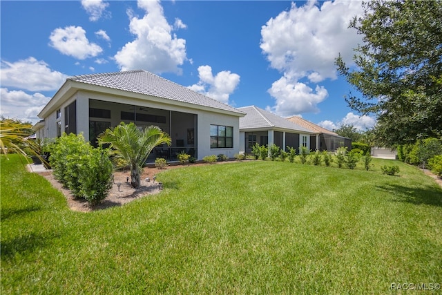 rear view of property with a sunroom and a yard