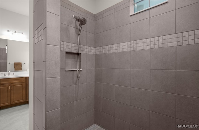 bathroom with vanity and a tile shower