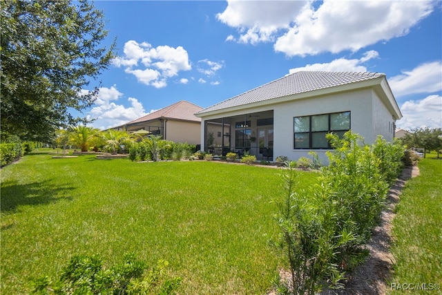 rear view of house with a sunroom and a yard