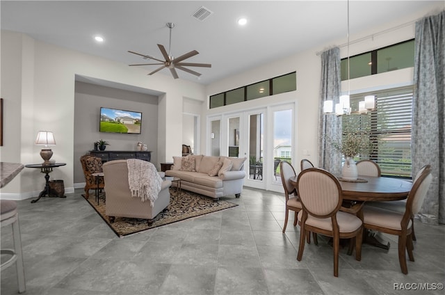 living room with a wealth of natural light and ceiling fan with notable chandelier