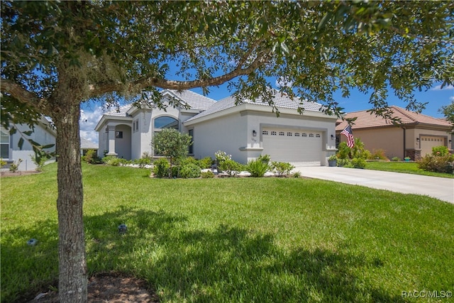 mediterranean / spanish home with a front lawn and a garage