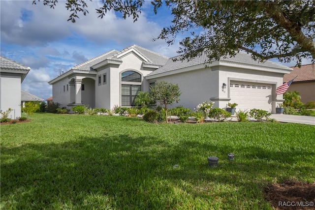 mediterranean / spanish-style house featuring a garage and a front lawn