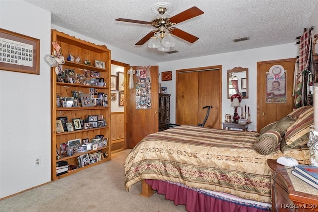 bedroom with a closet, a textured ceiling, light colored carpet, and ceiling fan