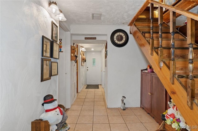 hallway with light tile patterned flooring and a textured ceiling