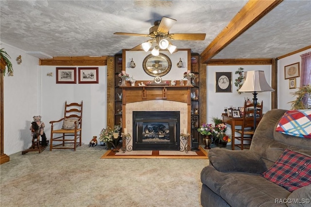 carpeted living room featuring a fireplace, beam ceiling, a textured ceiling, and ceiling fan