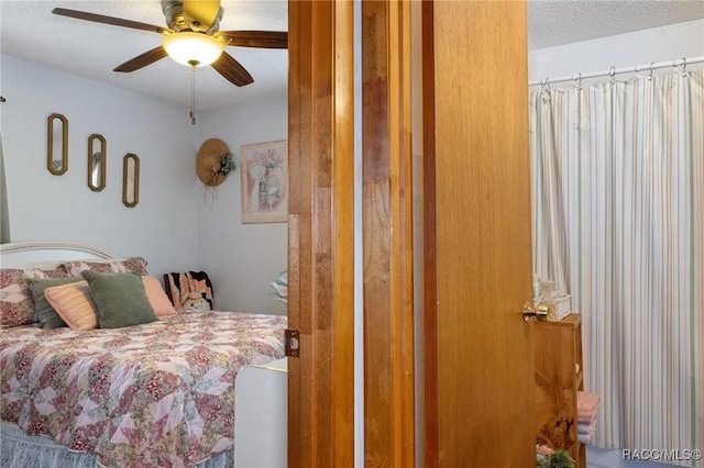 bedroom with ceiling fan and a textured ceiling