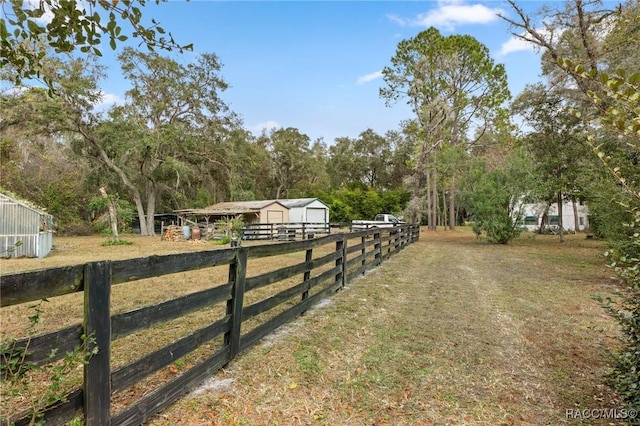 view of yard featuring a rural view and an outdoor structure