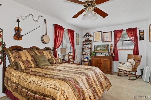 carpeted bedroom with ceiling fan and a textured ceiling