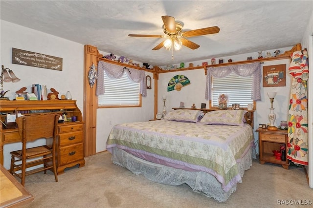 carpeted bedroom featuring ceiling fan and a textured ceiling