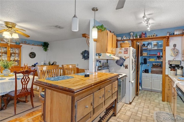 kitchen with a textured ceiling, range with electric stovetop, hanging light fixtures, and ceiling fan