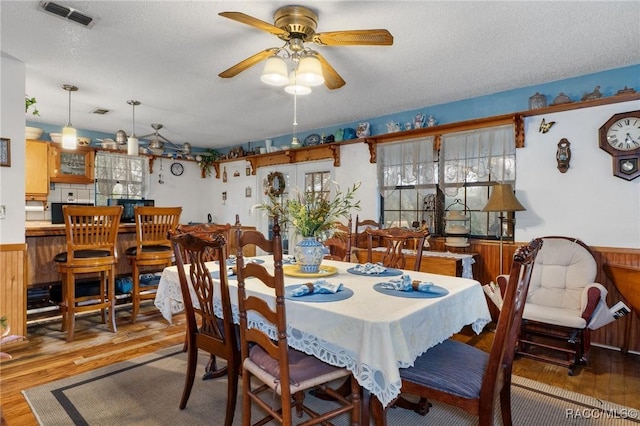 dining space featuring hardwood / wood-style floors, a textured ceiling, and ceiling fan