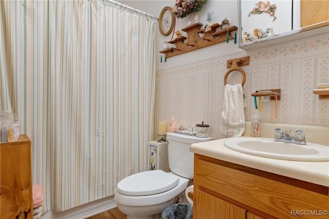 bathroom featuring vanity, toilet, and walk in shower