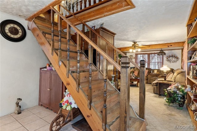 staircase with tile patterned flooring, a textured ceiling, and ceiling fan