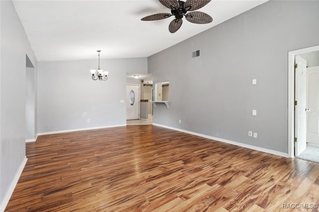 unfurnished living room featuring hardwood / wood-style floors, ceiling fan with notable chandelier, and vaulted ceiling