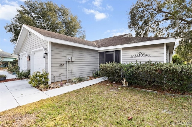 single story home featuring a garage and a front lawn