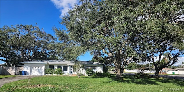 ranch-style home with a garage and a front lawn