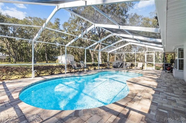 view of pool featuring a lanai, a shed, and a patio area