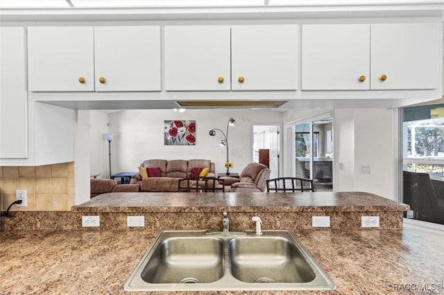 kitchen with decorative backsplash, sink, and white cabinetry