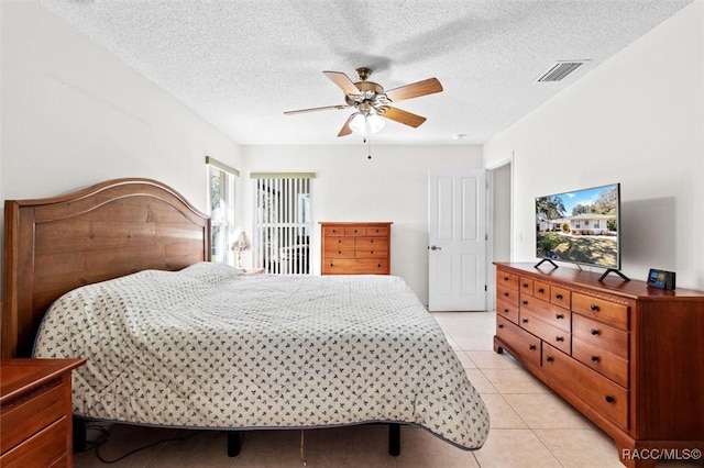 bedroom featuring a textured ceiling, ceiling fan, and light tile patterned floors