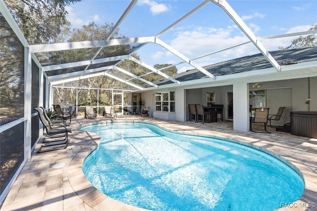 view of swimming pool with glass enclosure and a patio