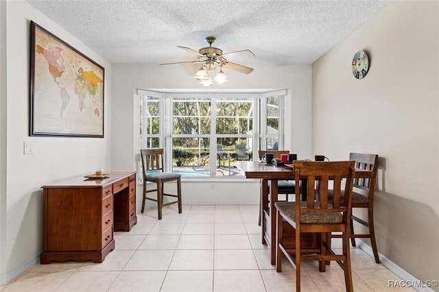 dining space with a textured ceiling, ceiling fan, and light tile patterned floors