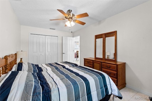 tiled bedroom featuring a textured ceiling, a closet, and ceiling fan