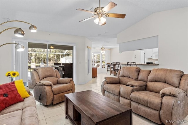 tiled living room featuring ceiling fan and vaulted ceiling