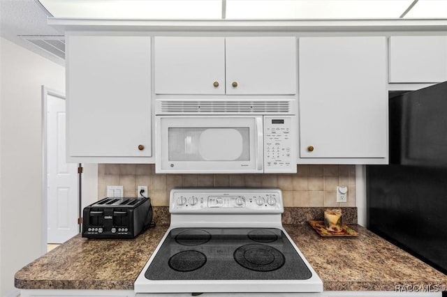 kitchen featuring decorative backsplash, white appliances, and white cabinetry