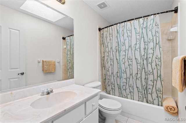 full bathroom with toilet, vanity, shower / bath combo, a skylight, and a textured ceiling