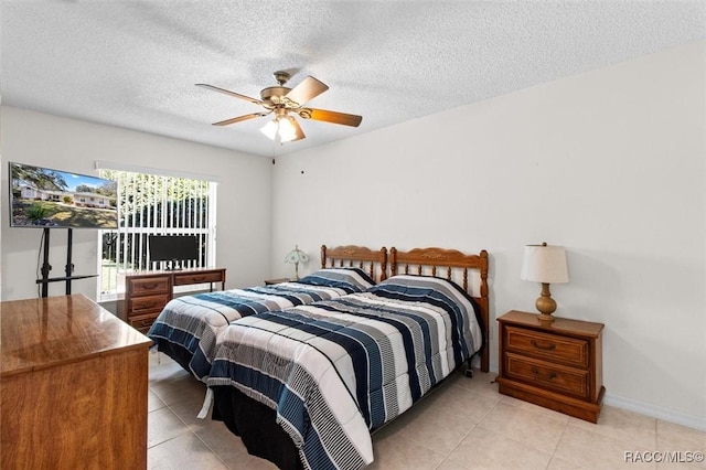 tiled bedroom with ceiling fan and a textured ceiling