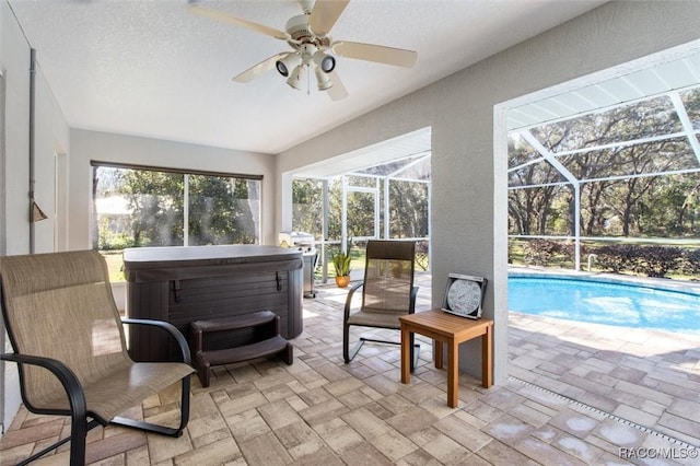 sunroom featuring ceiling fan, a swimming pool with hot tub, and a wealth of natural light