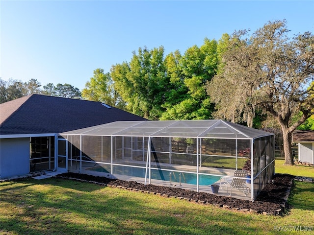 view of swimming pool with glass enclosure and a yard