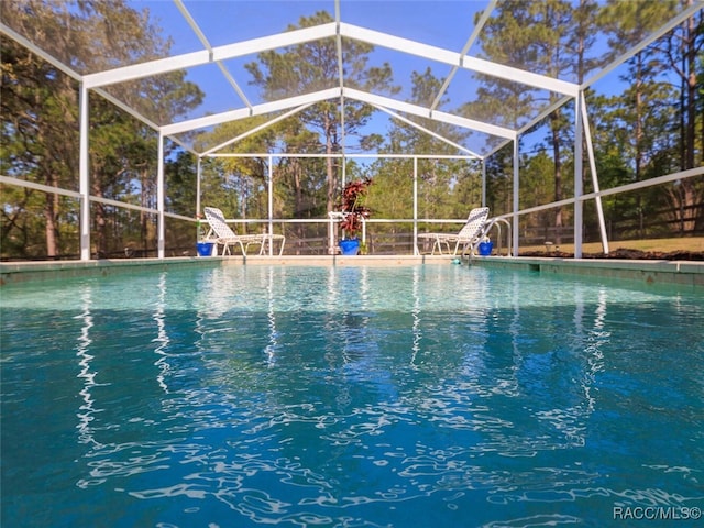 view of swimming pool featuring glass enclosure