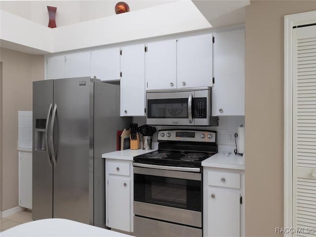 kitchen featuring backsplash, light tile patterned flooring, white cabinets, and stainless steel appliances