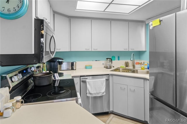 kitchen with sink, white cabinetry, and stainless steel appliances