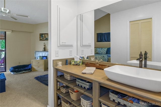 bathroom featuring ceiling fan, lofted ceiling, a textured ceiling, and vanity