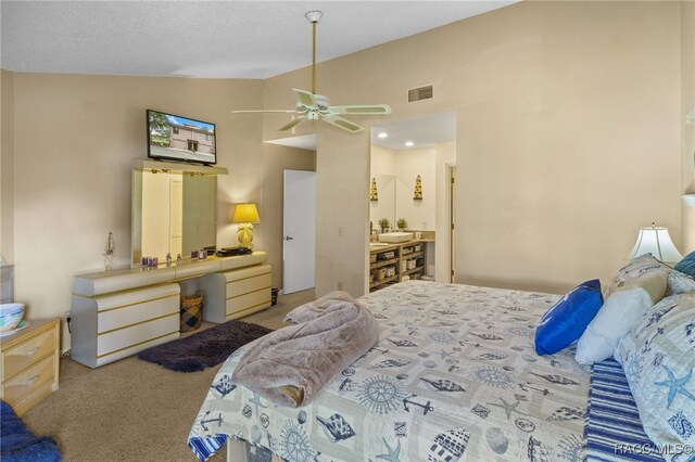 bedroom with ceiling fan, carpet floors, ensuite bathroom, and vaulted ceiling