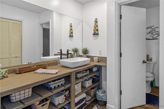 bathroom with toilet, vanity, and hardwood / wood-style flooring