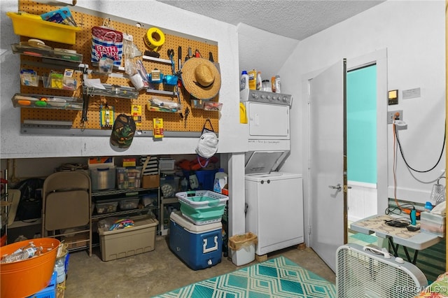 clothes washing area featuring a workshop area, stacked washer and dryer, and a textured ceiling